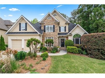 Charming two-story home with stone accents, lush landscaping, and a well-manicured front yard at 994 Fairview Club Cir, Dacula, GA 30019