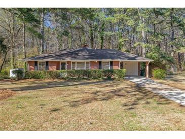 Charming single-story brick home with a well-manicured lawn and mature trees at 1672 Zemory Dr, Tucker, GA 30084