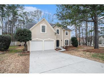 Two-story home featuring a two-car garage, neutral stucco and stone accents, and a well-manicured front yard at 725 Victoria Station Blvd, Lawrenceville, GA 30043