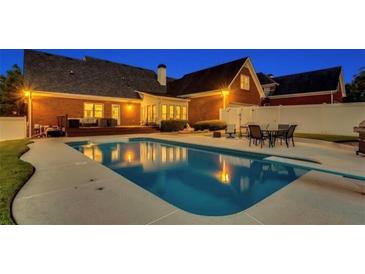 Stunning backyard pool with outdoor dining and deck seating at dusk for relaxation and entertainment at 1408 Aramore Dr, Conyers, GA 30013