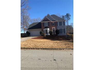 Traditional two-story home with a well-manicured lawn, a two-car garage, and a symmetrical facade at 222 Waterford Cove Dr, Suwanee, GA 30024