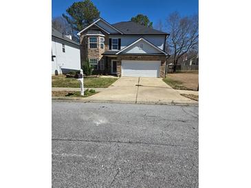 Charming two-story home with stone accents, a two-car garage, and a well-maintained front yard at 2251 Silver Maple Cir, Ellenwood, GA 30294