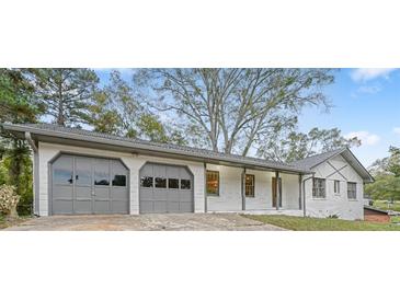 Charming single-story home featuring a two-car garage, gray trim, and a well-maintained front yard at 4647 Wonder Valley Trl, Decatur, GA 30034