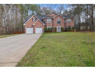 Traditional brick home with a well-manicured front lawn and an extended driveway at 504 Trotters Ln, Mcdonough, GA 30252