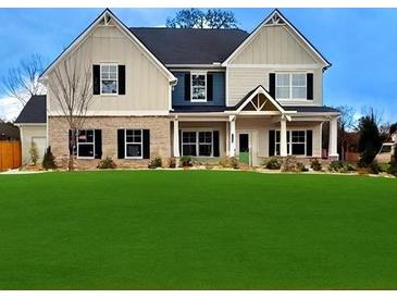 Charming two-story home with a well-manicured green lawn and a mix of stone and siding accents at 1381 Stephens View Dr, Loganville, GA 30052