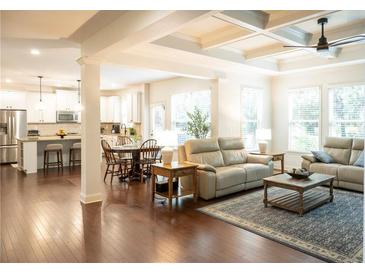 Spacious living room featuring hardwood floors, coffered ceilings, and open-concept design into kitchen at 4025 Toulon Ln, Cumming, GA 30040