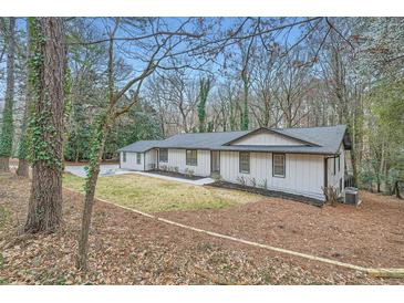 Charming ranch-style house with a well-maintained lawn and freshly painted exterior nestled in a lush wooded setting at 1555 Sunnybrook Farm Rd, Atlanta, GA 30350