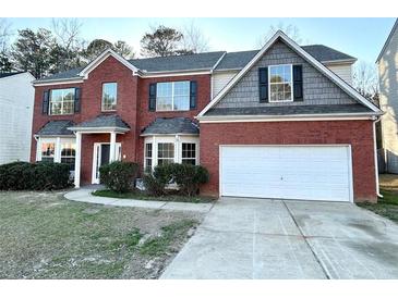 Charming two-story brick home with a two-car garage and manicured landscaping at 6159 Sable Fox Dr, Riverdale, GA 30296