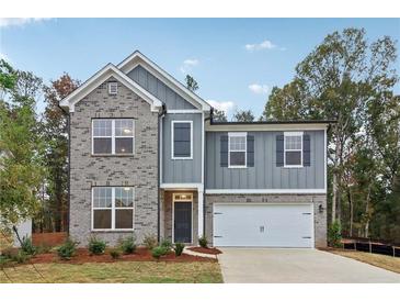 Charming two-story home with a brick and gray facade and a two-car garage, exuding curb appeal at 5384 Heron Bay Blvd, Locust Grove, GA 30248
