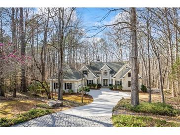 Charming exterior view of home with beautiful landscaping, long drive, and wooded surroundings at 285 Blackstock Rd, Villa Rica, GA 30180