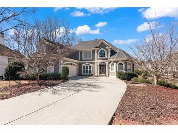 Stately two-story home with a long driveway, manicured landscaping, and a three-car garage at 160 Antler Trl, Alpharetta, GA 30005