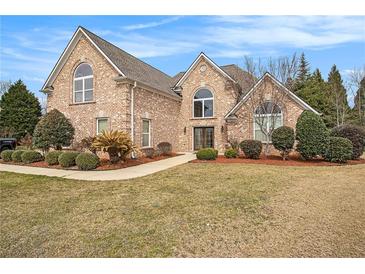 Charming brick home featuring manicured landscaping, arched windows, and a welcoming front entrance at 1132 Venetian Ln, Hampton, GA 30228