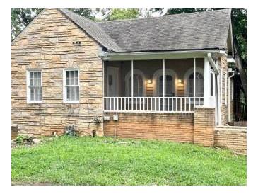 Charming stone cottage featuring a screened porch and well-maintained yard at 1247 Monroe Ne Dr, Atlanta, GA 30306
