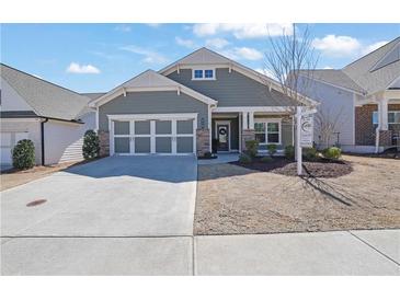 Charming single-story home featuring a two-car garage and manicured front yard with a for sale sign at 814 Spruce Ave, Canton, GA 30114