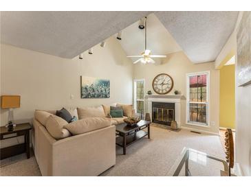 Comfortable living room boasts high ceilings, fireplace, plush sofa, and a ceiling fan for added relaxation at 917 Edgewater Cir, Marietta, GA 30062