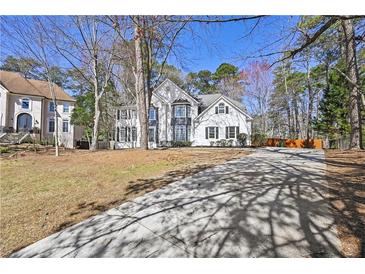 Inviting two-story home with a white exterior, black shutters and a long concrete driveway at 1303 Angel Falls Sw Ln, Atlanta, GA 30311