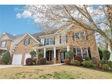 Charming two-story brick home with a welcoming front porch and meticulously landscaped front yard at 6945 W Mountain Xing, Cumming, GA 30041