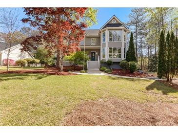 Charming two-story home with a lush front yard and beautiful landscaping, including an eye-catching red maple at 8078 Longleaf Dr, Villa Rica, GA 30180