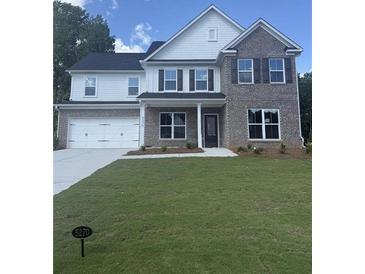 Two-story home featuring a combination of brick and siding, complemented by a neatly maintained lawn at 5310 Julep Ct, Cumming, GA 30028