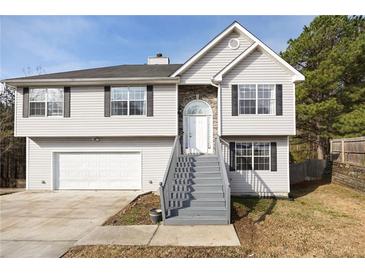 Charming two-story home with light gray siding, stone accents, and inviting front entrance at 6595 Lancelot Ct, Riverdale, GA 30296