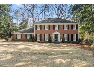 Beautiful two-story brick home with a manicured lawn and traditional architectural details at 2947 Margaret Mitchell Nw Ct, Atlanta, GA 30327