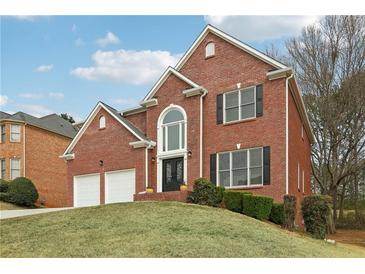 Charming two-story brick home with a two-car garage, manicured lawn and attractive front door at 5960 Magnolia Rdg, Stone Mountain, GA 30087