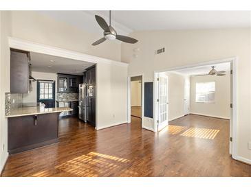 Open-concept living room featuring hardwood floors and seamless access to the modern kitchen at 1526 Stone Gate Se Ln, Atlanta, GA 30317