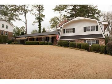 Charming home with manicured landscaping, inviting front porch, and American flag at 1728 Stonecliff Ct, Decatur, GA 30033