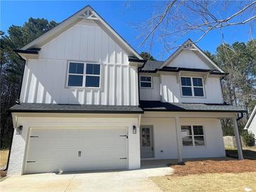 Charming two-story home featuring white siding, a two-car garage, and a well-manicured lawn at 1335 Tumblerock Way, Loganville, GA 30052