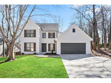 Charming two-story home features a brick facade, well-maintained lawn, and an attached two-car garage at 275 Carriage Chase, Fayetteville, GA 30214