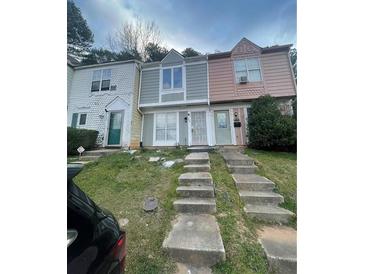 Charming townhomes featuring unique exteriors and inviting front entrances with concrete steps at 404 Prince Of Wales, Stone Mountain, GA 30083