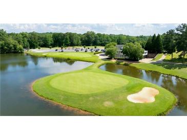Scenic aerial view of a lush golf course with a pond and clubhouse, perfect for luxury living at 49 Inverness Ct, Hiram, GA 30141