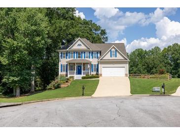 Charming two-story home with blue shutters, white trim and a well-manicured lawn on a sunny day at 49 Inverness Ct, Hiram, GA 30141