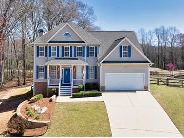 Charming two-story home featuring blue shutters, a well-manicured lawn, and a two-car garage at 49 Inverness Ct, Hiram, GA 30141