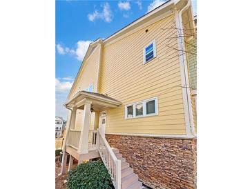 Charming home with stone accents, light yellow siding and a welcoming entry staircase at 3628 Princeton Ave, Atlanta, GA 30337