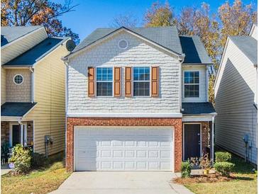 Two-story home featuring a brick-base, attached garage, and light brown shutters at 5171 Hanover St, Atlanta, GA 30349