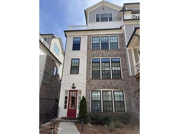 Three story townhome with brick and Hardie board exterior, red door and black trim at 323 Concord St, Alpharetta, GA 30009