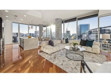 Bright living room features floor-to-ceiling windows, hardwood floors, and modern furnishings at 1080 Peachtree Ne St # 2011, Atlanta, GA 30309