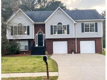 Charming two-story home with a brick and vinyl exterior, complemented by a well-manicured lawn and a two-car garage at 153 Rockport Dr, Mcdonough, GA 30253