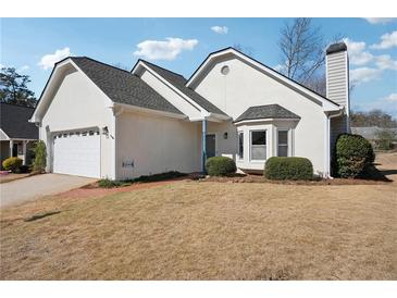 Attractive stucco home featuring an attached garage and manicured landscaping at 4010 Arborwood Ln, Tucker, GA 30084