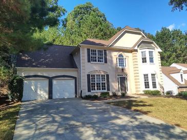 Charming two-story home with a two-car garage, manicured lawn, and mature trees at 2015 Aldbury Ln, Woodstock, GA 30189