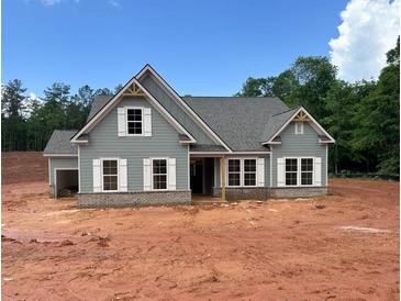 Charming single-Gathering home featuring light gray siding, a gray roof, white trim, and a brick foundation at 1239 Pj East Rd, Covington, GA 30014