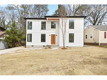 Modern two-story home with white siding, black trim and an orange front door at 1650 Eastport Se Ter, Atlanta, GA 30317