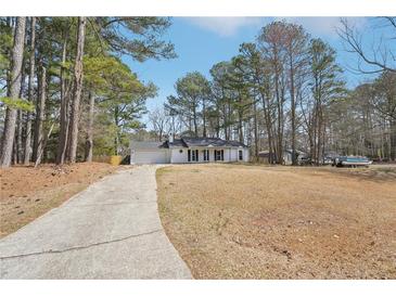 Charming one-story home with a well-maintained lawn and a long driveway at 489 Natasha Dr, Auburn, GA 30011