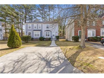 Charming townhome featuring a well-manicured front yard with mature trees and a private driveway at 5940 Hampton Ct, Atlanta, GA 30349