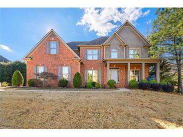 Charming brick home with a well-manicured lawn, complemented by a cozy front porch and lush green shrubs at 4005 Princeton Trce, Cumming, GA 30041