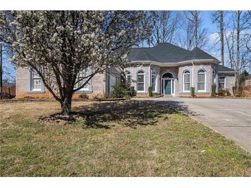 Charming brick home with a well-maintained lawn and blossoming tree in a suburban neighborhood at 3901 Cherry Ridge Blvd, Decatur, GA 30034