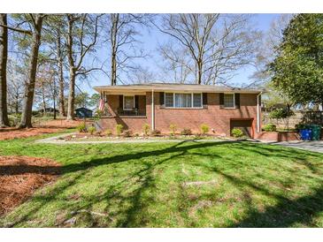 Charming brick home featuring a well-manicured lawn and a cozy front porch at 2780 Eastfield Se Rd, Smyrna, GA 30080