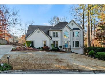 Charming two-story home with a well-manicured lawn and a beautiful blue front door at 1190 Midland Way, Lawrenceville, GA 30043