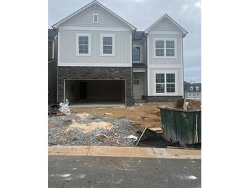 Two-story exterior elevation with an open garage and stone accents at the base of the home at 270 Lakeside Place, Canton, GA 30114